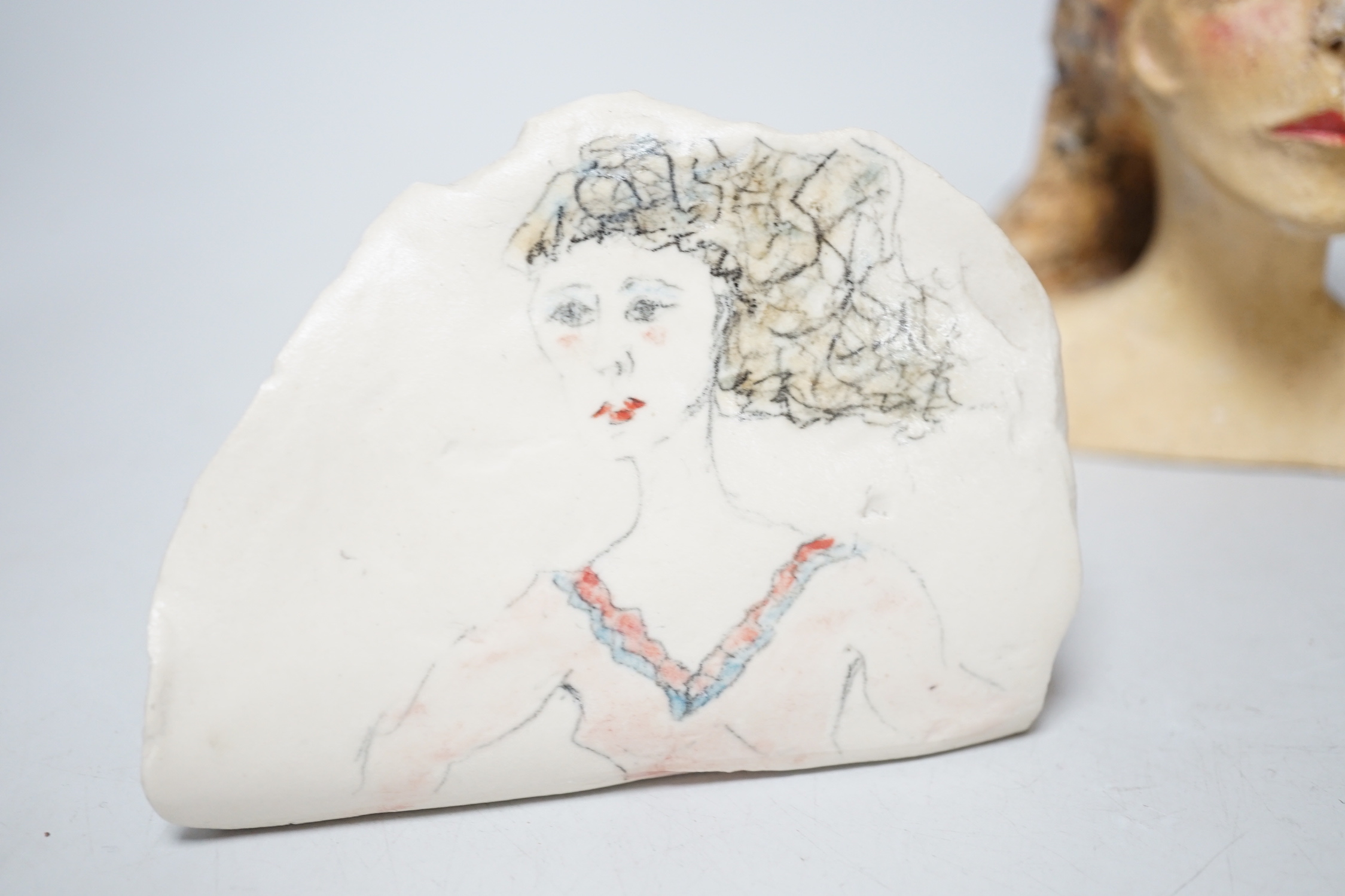 Coral Pearson-Revel (New Zealand) - three works - a painted terracotta head and shoulders of a woman, 12cm, a terracotta woman’s torso, dated 2007 and a half circle plaque, painted with a bust of a woman, each signed